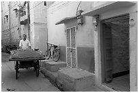 Man with vegetables car in front of painted house. Jodhpur, Rajasthan, India ( black and white)
