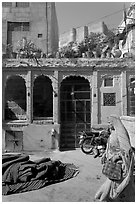 Woman in sari, blue house, and fort in the distance. Jodhpur, Rajasthan, India ( black and white)