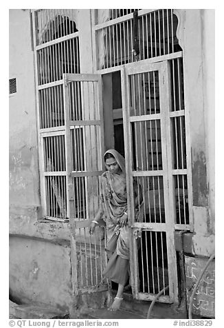 Woman stepping out of door. Jodhpur, Rajasthan, India (black and white)