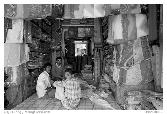 Men in shop selling colorful fabrics, Sardar market. Jodhpur, Rajasthan, India (black and white)