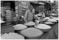 Man in front of grain and spice store, Sardar market. Jodhpur, Rajasthan, India (black and white)