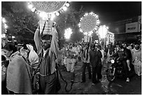 Men carrying bright electric signs during wedding procession. Varanasi, Uttar Pradesh, India (black and white)