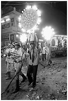 Uniformed musicians and men carrying lights during wedding procession. Varanasi, Uttar Pradesh, India (black and white)