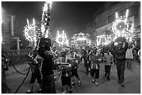 Musicians, men carrying lights, and carriage during wedding procession. Varanasi, Uttar Pradesh, India ( black and white)