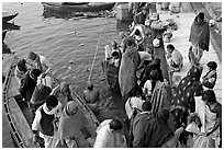 Hindu pilgrims walk out of boat onto Dasaswamedh Ghat. Varanasi, Uttar Pradesh, India ( black and white)