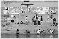 People washing cloths, steps, and Indi inscriptions. Varanasi, Uttar Pradesh, India (black and white)