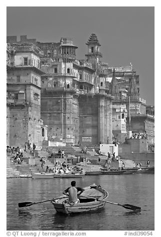 Man rowing boat beneath Munshi Ghat. Varanasi, Uttar Pradesh, India (black and white)