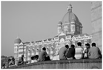 Men sitting in front of Taj Mahal Palace Hotel. Mumbai, Maharashtra, India ( black and white)