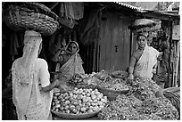 Women with baskets on head buying vegetables, Colaba Market. Mumbai, Maharashtra, India ( black and white)