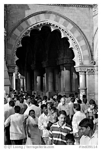 Crowd pass beneath an archway, Chhatrapati Shivaji Terminus. Mumbai, Maharashtra, India (black and white)