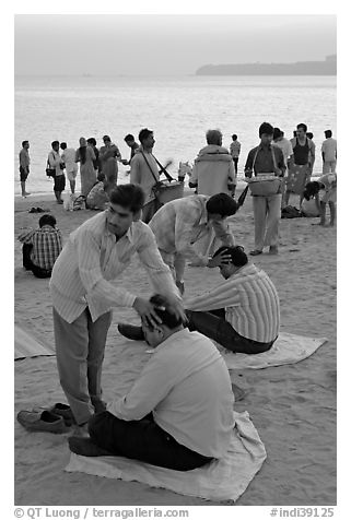 Head rub given by malish-wallah, Chowpatty Beach. Mumbai, Maharashtra, India (black and white)