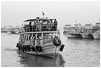 Tour boat loaded with passengers. Mumbai, Maharashtra, India ( black and white)