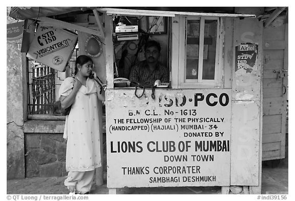 Woman at a street telephone booth. Mumbai, Maharashtra, India (black and white)