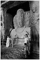 Woman and children standing in front of Mahesh Murti, main  Elephanta cave. Mumbai, Maharashtra, India ( black and white)