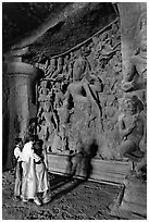 Family looking at Ardhanarishwar Siva sculpture, main Elephanta cave. Mumbai, Maharashtra, India ( black and white)