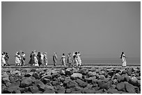 Women walking on  jetty in the distance, Elephanta Island. Mumbai, Maharashtra, India ( black and white)