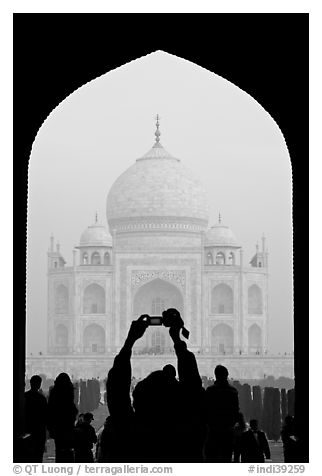 Tourist pointing  digital camera to Maj Mahal, framed by arch of gateway. Agra, Uttar Pradesh, India