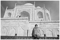 Woman sitting at the base of Taj Mahal looking up. Agra, Uttar Pradesh, India ( black and white)