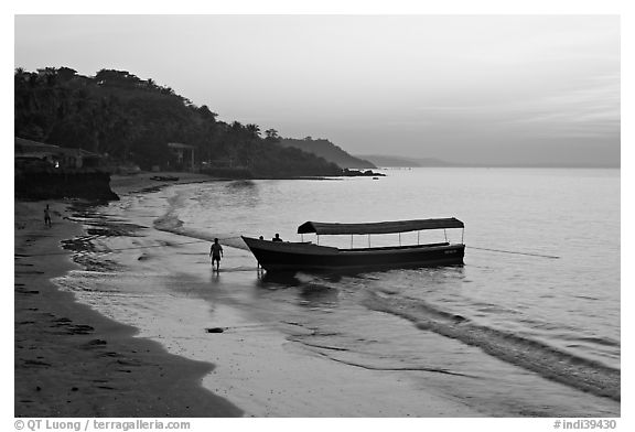 Narrow boat on beach at dawn, Dona Paula. Goa, India (black and white)