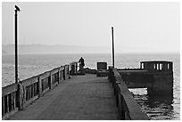 Pier with man fishing, early morning, Dona Paula. Goa, India (black and white)