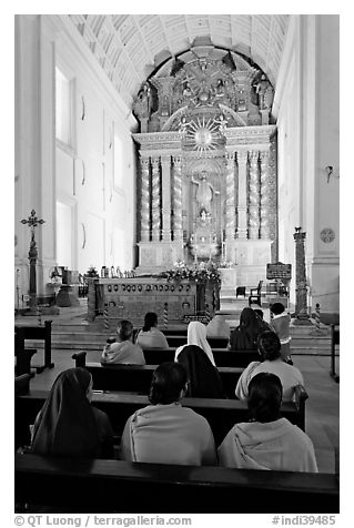 Indian women sitting in front of the altar, Basilica of Bom Jesus, Old Goa. Goa, India (black and white)