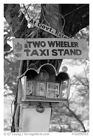 Two wheeler taxi stand and altar on tree. Goa, India