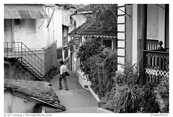 Man in alley with gardens, Panjim. Goa, India