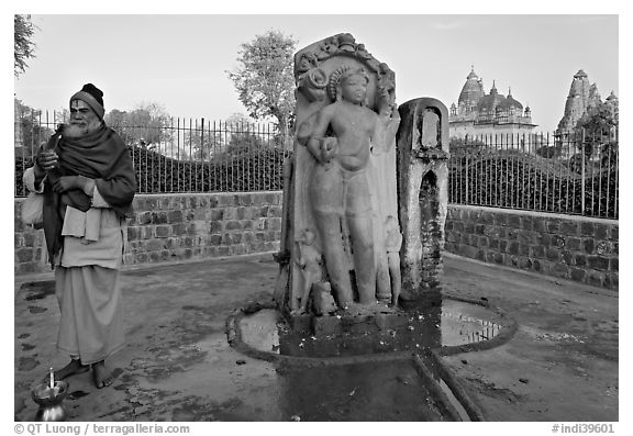 Holy man next to Shiva image. Khajuraho, Madhya Pradesh, India (black and white)