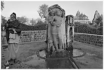 Holy man next to Shiva image. Khajuraho, Madhya Pradesh, India ( black and white)