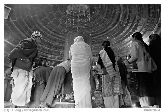 Worshipers and polished lingam inside Matangesvara temple. Khajuraho, Madhya Pradesh, India (black and white)