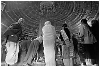 Worshipers and polished lingam inside Matangesvara temple. Khajuraho, Madhya Pradesh, India ( black and white)