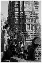 Women offering morning puja  in front temple spire. Khajuraho, Madhya Pradesh, India (black and white)