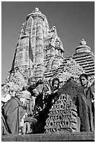 Hindu worshippers making offerings with Lakshmana temple behind. Khajuraho, Madhya Pradesh, India (black and white)
