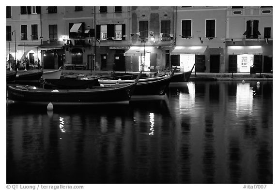 Light of shops reflected in harbor at dusk, Portofino. Liguria, Italy (black and white)