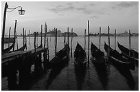 Parked gondolas, Canale della Guidecca, San Giorgio Maggiore church at dawn. Venice, Veneto, Italy (black and white)
