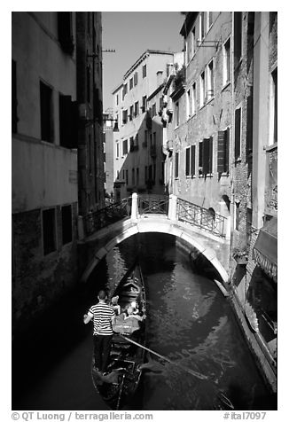 Gondola tour in a picturesque canal with bridge. Venice, Veneto, Italy