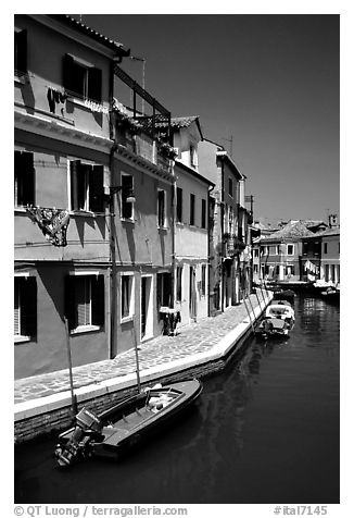 Canal surrounded by houses painted  a multitude of bright colors, Burano. Venice, Veneto, Italy (black and white)