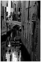 Pedestrians on a bridge over a narrow canal. Venice, Veneto, Italy (black and white)