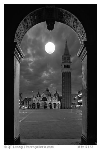 Campanile and Piazza San Marco (Square Saint Mark) seen from arcades at night. Venice, Veneto, Italy