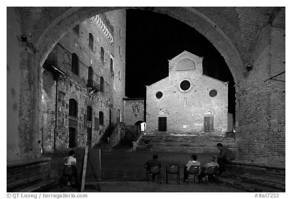 Duomo framed by an arch at night. San Gimignano, Tuscany, Italy