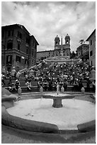 Fontana della Barcaccia and Spanish Steps covered with tourists sitting. Rome, Lazio, Italy ( black and white)