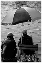 Men fishing under an colorful sun unbrella,  Agropoli. Campania, Italy (black and white)