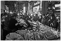 Unusual street foods on busy shopping street. Seoul, South Korea ( black and white)