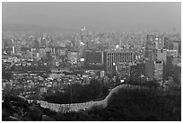 Old fortress wall and high-rises at dusk. Seoul, South Korea (black and white)