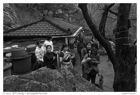 Hikers drinking from foundtain at Sangseonam hermitage, Namsan Mountain. Gyeongju, South Korea (black and white)