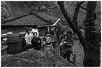 Hikers drinking from foundtain at Sangseonam hermitage, Namsan Mountain. Gyeongju, South Korea ( black and white)