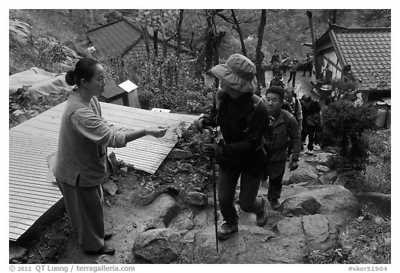 Woman giving sacred bread at Sangseonam hermitage, Namsan Mountain. Gyeongju, South Korea