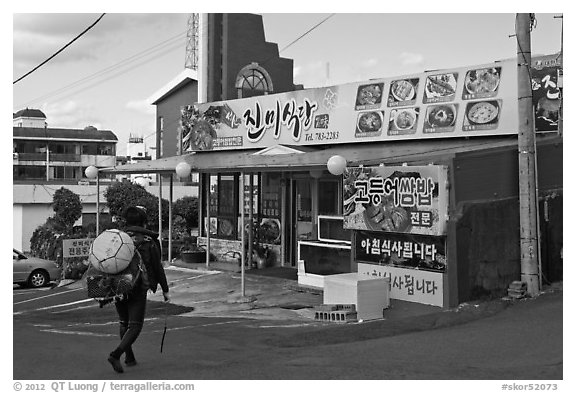 Haeneyo woman walking towards seafood restaurant. Jeju Island, South Korea (black and white)