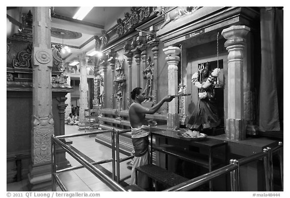 Holy man lights altar inside Sri Mariamman Temple. George Town, Penang, Malaysia (black and white)