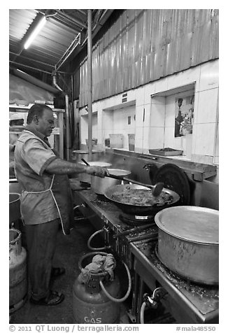 Man frying food in large pan. George Town, Penang, Malaysia (black and white)